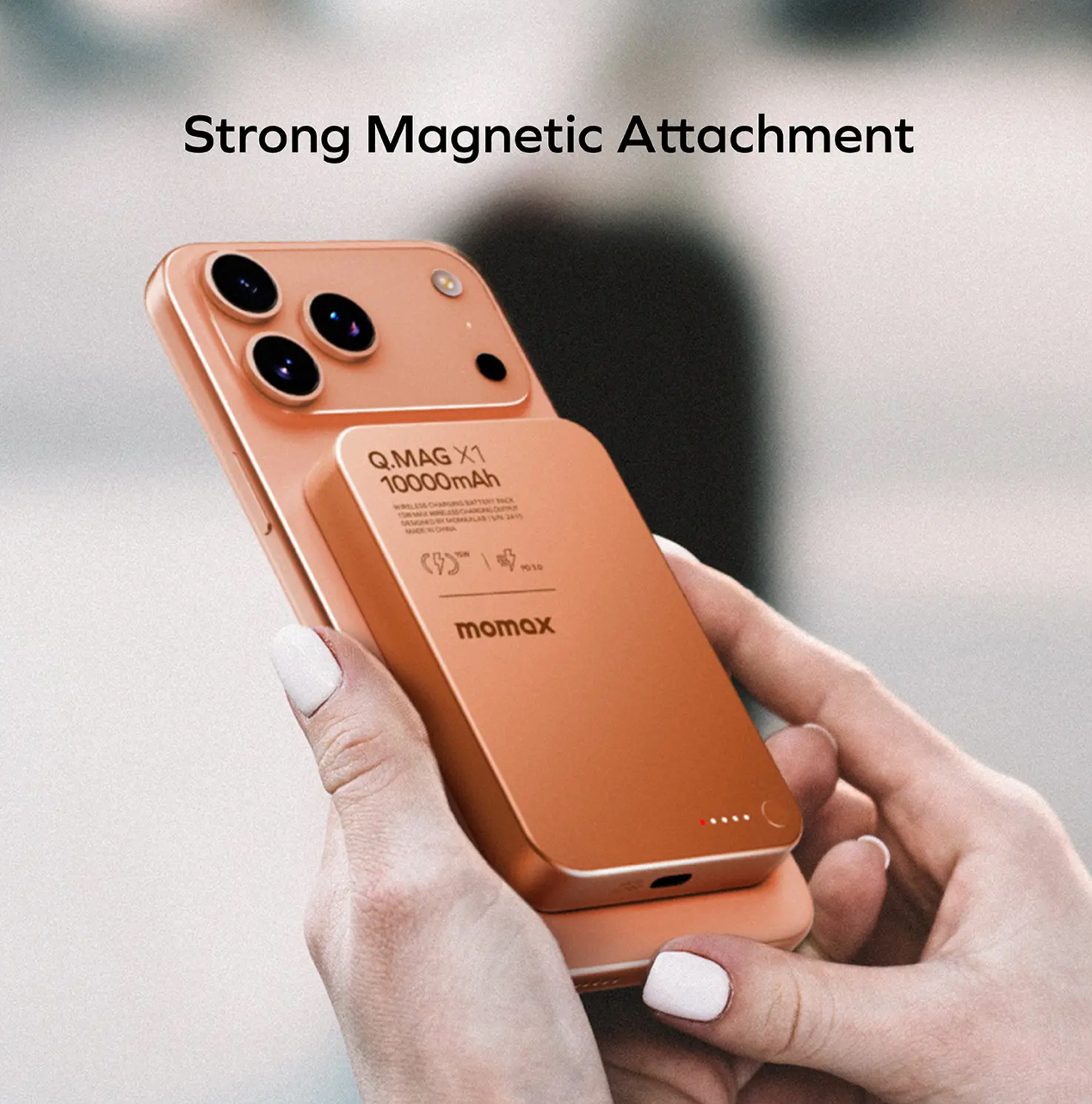 Надёжное магнитное крепление оранжевого MOMAX Q.MAG X1 к смартфону в руках